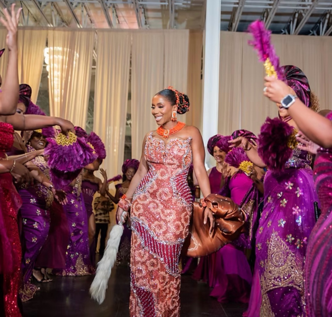 Bride in coral beaded gown dancing with her party