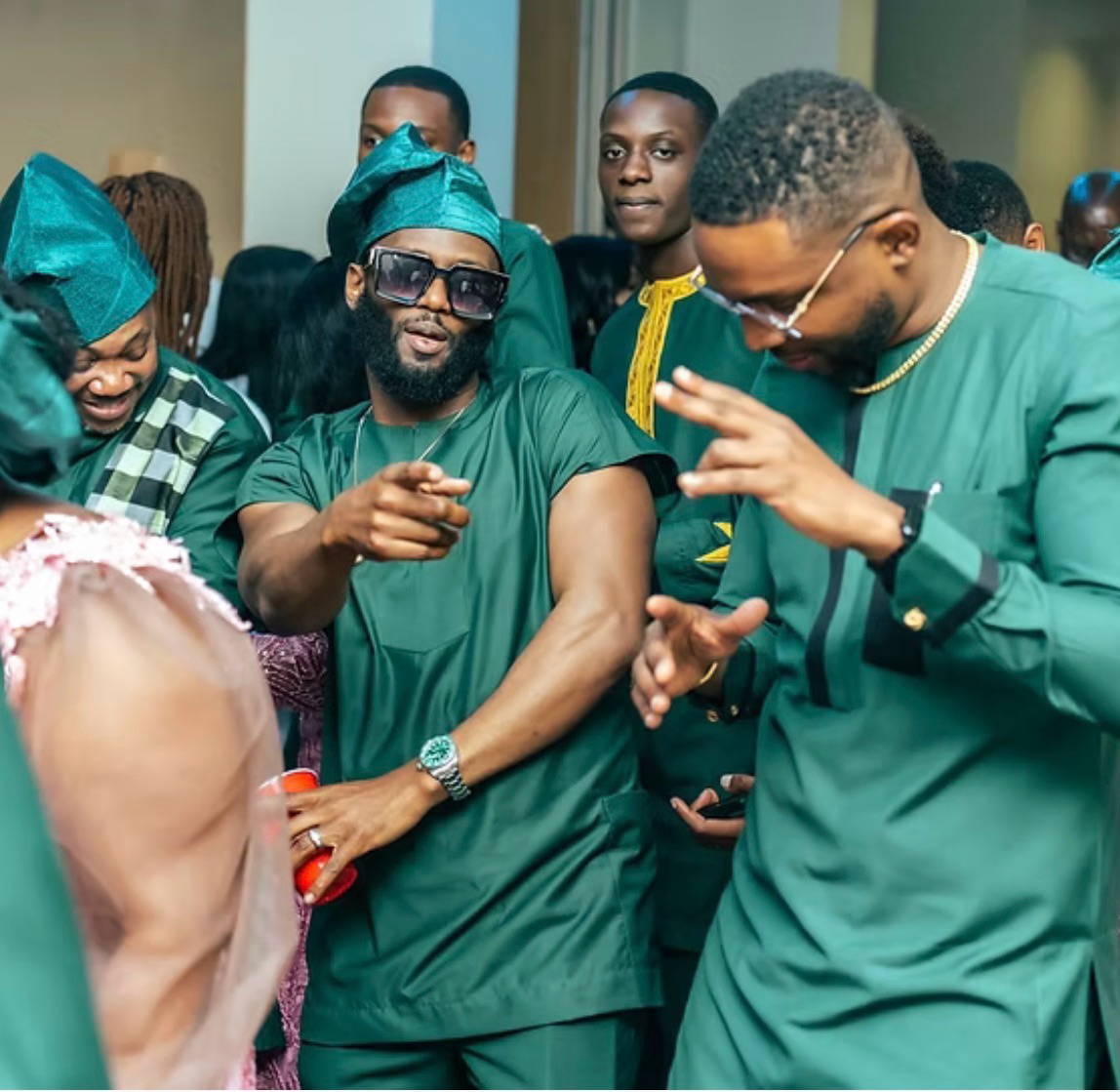Men in emerald kaftans dancing at a wedding